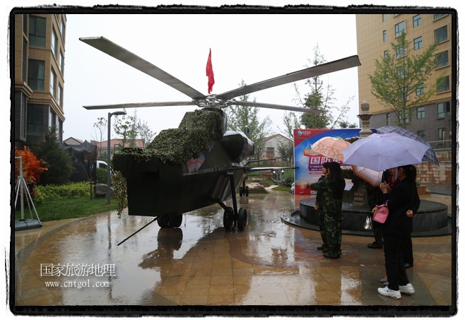 小區(qū)突然出現(xiàn)“飛機(jī)坦克”，其中殲15艦載戰(zhàn)斗機(jī)一架、99式主戰(zhàn)坦克一輛、武直-10武裝直升機(jī)一架，吸引了眾多市民雨中圍觀、合影。